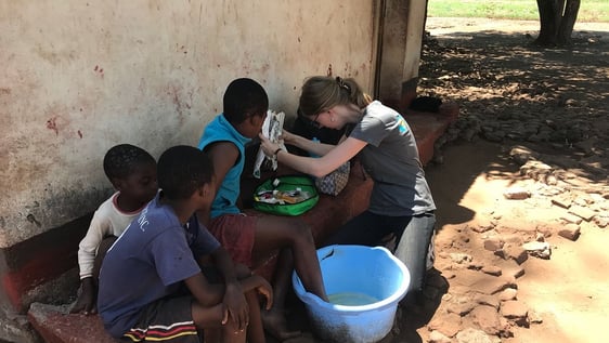Volunteer cleaning children's wounds