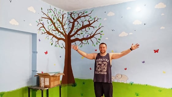 Volunteers painting murals in a school classroom in Jaipur, India