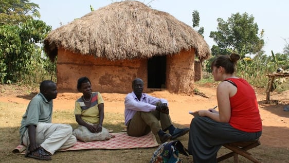 Volunteer fetching water in a community's new natural spring well