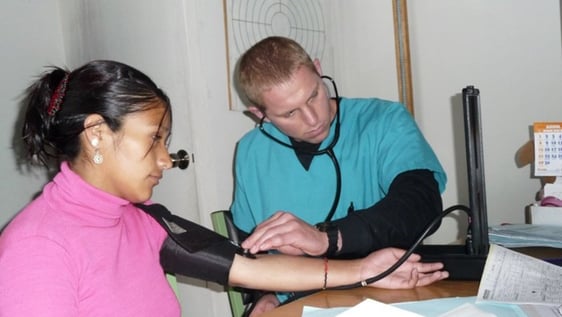 Volunteer taking a patient blood pressure reading at a community clinic in Cusco