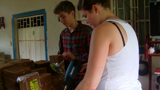 Volunteer helping to pack panela in one of the Sugar Cane farms after the milling process.