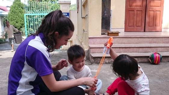 A volunteer with children at a Hanoi disability centre