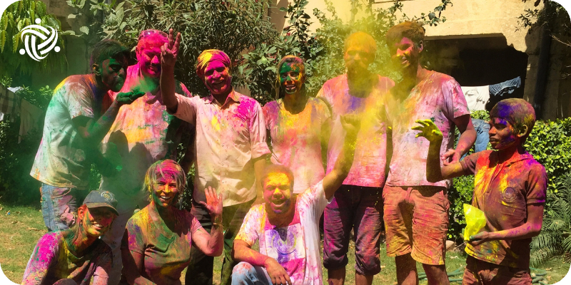 A Volunteer with people from India throwing Holy festival Colors around.